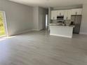 Open floor plan with light gray floors connecting the kitchen, dining, and living areas at 21 Pine Course Trak, Ocala, FL 34472