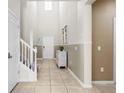 Bright entryway with high ceilings, neutral tones, tile flooring, and a staircase at 2161 Lelani Cir, Davenport, FL 33897