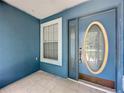 Inviting front porch features a decorative door, tile flooring, and a window at 238 Sunridge Woods Blvd, Davenport, FL 33837