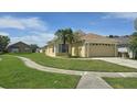 Charming one-story home featuring a well-manicured lawn and an attached two-car garage at 2401 Cedarfield Ln, Kissimmee, FL 34744