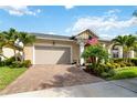 Single Gathering home with a brick driveway, lovely landscaping, and an American flag on the porch at 2736 Southland St, St Cloud, FL 34772