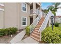 Close-up of condo stairs with white railings and mature landscaping at 2832 Osprey Cove Pl # 102, Kissimmee, FL 34746