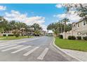 Gated entrance to Osprey Cove featuring mature trees and well-maintained landscaping at 2832 Osprey Cove Pl # 102, Kissimmee, FL 34746