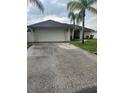 Home exterior featuring a two-car garage and neutral paint scheme at 306 Clermont Dr, Kissimmee, FL 34759