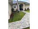 Charming stone walkway leading to the front door with attractive landscaping at 306 Clermont Dr, Kissimmee, FL 34759