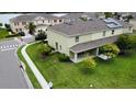 Aerial view of a backyard with a covered patio, showcasing green lawn and nearby lake at 403 Arbor Lakes Dr, Davenport, FL 33896