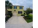 Charming two-story home with a large concrete driveway, green lawn, and carefully planted landscaping at 403 Arbor Lakes Dr, Davenport, FL 33896