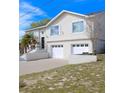 Two-story home with white siding, two-car garage, palm tree, and landscaped front yard at 4151 Nelson Rd, Lake Wales, FL 33898
