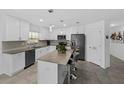 Modern kitchen features white cabinets, stainless steel appliances, center island, and tiled floors at 4338 Finch Ln, Kissimmee, FL 34746
