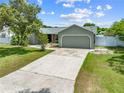 View of the single-story home featuring an attached garage and concrete driveway at 4607 Pine Lake Dr, St Cloud, FL 34769