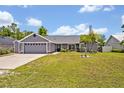 Landscaped single-story home with gray siding, lush lawn, and inviting curb appeal at 6396 Bennett Ct, St Cloud, FL 34771
