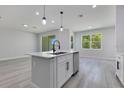 Bright kitchen featuring an island with a sink, stainless steel dishwasher, and sliding glass door at 7 Spring Pass, Ocala, FL 34472