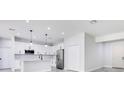 Modern, open-concept kitchen with white cabinets, stainless steel appliances, and a kitchen island at 7 Spring Pass, Ocala, FL 34472