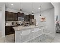Modern kitchen featuring dark cabinets, granite countertops, stainless steel appliances, and a spacious island with seating at 8897 Rhodes St, Kissimmee, FL 34747