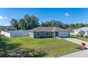 Well-maintained home featuring a fenced yard and long driveway leading to the attached garage at 10 Pine Track Trl, Ocala, FL 34472
