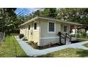 Side view of a bright home featuring manicured landscaping, a small porch and freshly painted exterior at 1602 W 12Th St, Sanford, FL 32771