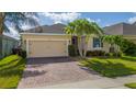 Lovely single-story home boasts a two car garage, brick driveway, and lush landscaping at 1703 Leatherback Ln, St Cloud, FL 34771
