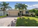 Beautiful single-story home featuring a well-kept lawn, brick driveway and mature palm trees at 1703 Leatherback Ln, St Cloud, FL 34771