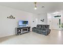 Bright living room with tiled floors, modern furniture, and large windows letting in ample sunlight at 2668 Coachman Dr, Deltona, FL 32738