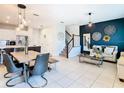 Open-concept living and dining area with stylish decor, tile floors, and a staircase at 2698 Chantilly Ave, Kissimmee, FL 34741