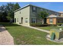 Two-story townhouse with well-kept lawn, neat shrubbery, and brick walkway to the front door at 2940 Tanzanite Ter, Kissimmee, FL 34758