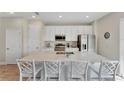 Bright kitchen with stainless steel appliances, a large island, and bar stool seating for casual dining at 2993 Caribbean Soul Dr, Kissimmee, FL 34747