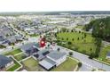 Aerial view of a neighborhood with a park, lake, and homes, pinpointing a home with solar panels at 3193 Crispin Cir, Harmony, FL 34773