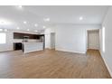 Open-concept living room with wood-look flooring and a kitchen island at 328 Lily Ln, Davenport, FL 33837