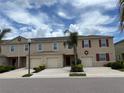 Inviting two-story townhome with a one-car garage, neutral siding, and manicured landscaping at 359 Arbor Lakes Dr, Davenport, FL 33896