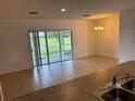 Open-concept living area with tile flooring, natural light, and sliding glass doors to the patio at 359 Arbor Lakes Dr, Davenport, FL 33896