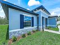 Charming single-story home with blue shutters and stone accents, surrounded by a lush, green lawn and landscaping at 41 Orchid Ct, Kissimmee, FL 34759
