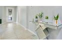 Bright foyer featuring tile flooring, a modern glass console table, and a decorative front door at 4918 Wildwood Pointe Rd, Winter Garden, FL 34787