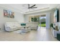 Spacious living room with a modern white sofa, ceiling fan, and a sliding glass door to the backyard at 4918 Wildwood Pointe Rd, Winter Garden, FL 34787