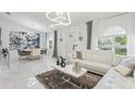 Spacious living room and dining area featuring white marble floors, modern lighting, and stylish decor at 512 Yellow Tail Pl, Chuluota, FL 32766