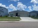 Beautiful single-story home featuring a gray exterior, a two-car garage, and manicured landscaping at 568 Meadow Bend Dr, Davenport, FL 33837