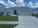 Charming single-story home featuring a gray exterior, a two-car garage, and well-maintained landscaping at 568 Meadow Bend Dr, Davenport, FL 33837
