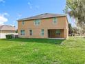 Spacious backyard with lush green grass, and the rear exterior of the home at 771 Cavan Dr, Apopka, FL 32703