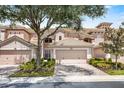 Charming townhome featuring a well-maintained tile roof, two-car garage, and landscaped front yard at 8401 Riverdale Ln # 8401, Davenport, FL 33896