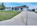 Exterior view of a single-story home with a long driveway and well-maintained lawn at 925 Roswell Ter, Deltona, FL 32738