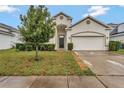 Lovely single-Gathering house with a manicured lawn, mature tree, and a two-car garage at 954 Revere Ave, Haines City, FL 33844