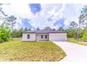Well-maintained one-story home featuring a two-car garage, simple landscaping and a neutral color palette at 13 Oak Trail Pl, Ocala, FL 34472