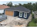 Side view of a newly built home with a dark blue exterior and a boarded-up garage at 1522 Pine St, Orlando, FL 32824