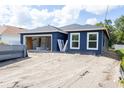New construction home with dark blue exterior, an open garage and unfinished landscaping at 1522 Pine St, Orlando, FL 32824