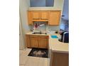Functional kitchen space with light wood cabinetry, a stainless steel sink, and ample counter space, ideal for meal preparation at 2141 Fawn Meadow Cir, St Cloud, FL 34772