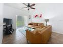 Cozy living room featuring tan leather couches, tile flooring, and sliding glass doors at 226 Verona Ave, Davenport, FL 33897