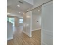Open-concept living area with wood-look floors and modern sliding barn doors at 2673 Calistoga Ave, Kissimmee, FL 34741
