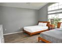 Bright bedroom featuring two beds, wood-look floors, a high ceiling, and a large window at 2807 Playing Otter Ct, Kissimmee, FL 34747