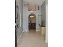 Inviting foyer with tile flooring, arched doorways, and decorative wall art leading into the dining area at 2807 Playing Otter Ct, Kissimmee, FL 34747