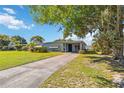 Inviting single-story home with a well-manicured lawn and mature trees, offering shade and curb appeal at 2830 W Oak St, Kissimmee, FL 34741