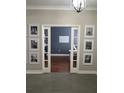 Hallway displaying Gathering photos, leading to a room with a blue accent wall and white trim at 3339 Primrose Willow Dr, St Cloud, FL 34773